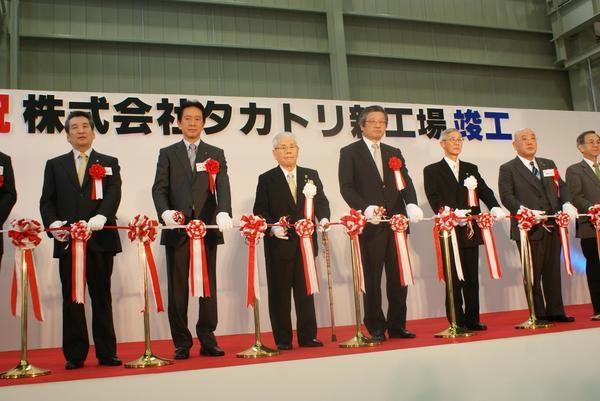 新工場竣工披露祝賀会でテープカットをしている関係者の方々の写真